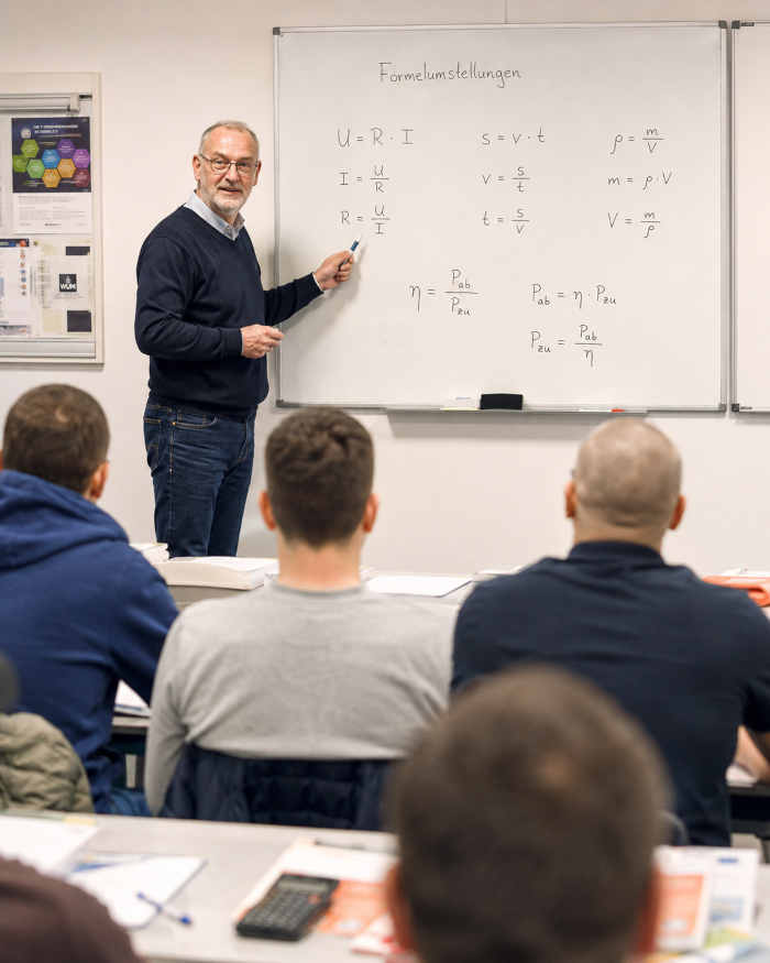 mathematik-lehrer-zeigt-an-whiteboard-das-umstellen-von-formeln Mathematik für Meisterschüler - demonstriert von einem Lehrer, der das Umstellen von Formeln demonstriert